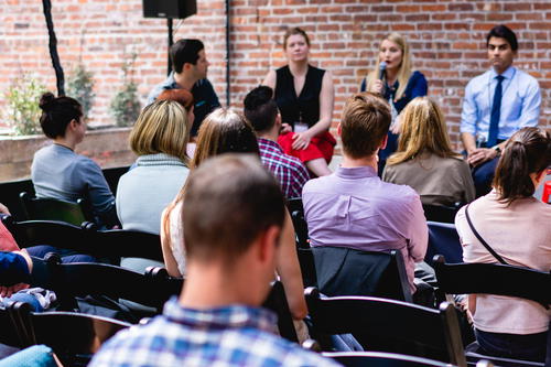 A group of people sitting in chairs and listening to a speaker.