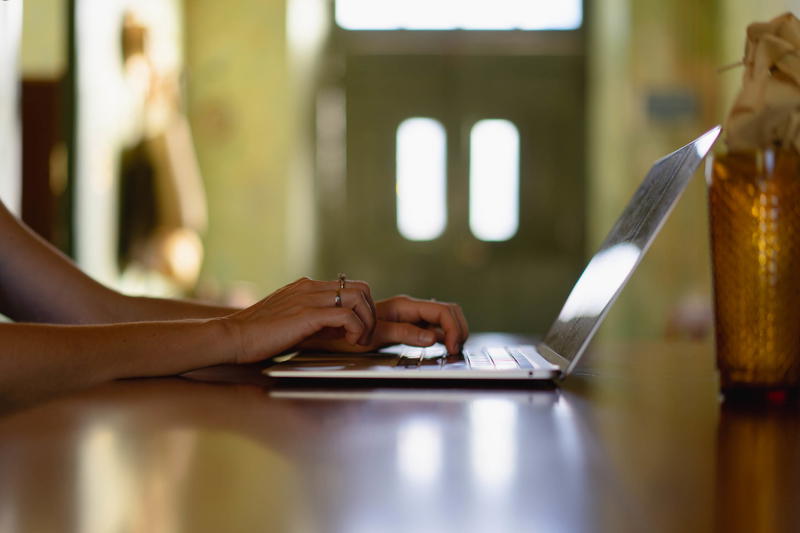 A woman typing on a laptop at a table.