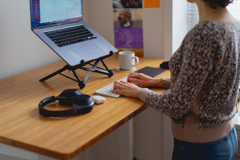A woman typing on a laptop at a desk.