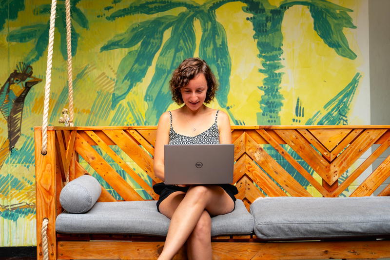 Woman on a bench with a dell computer outside