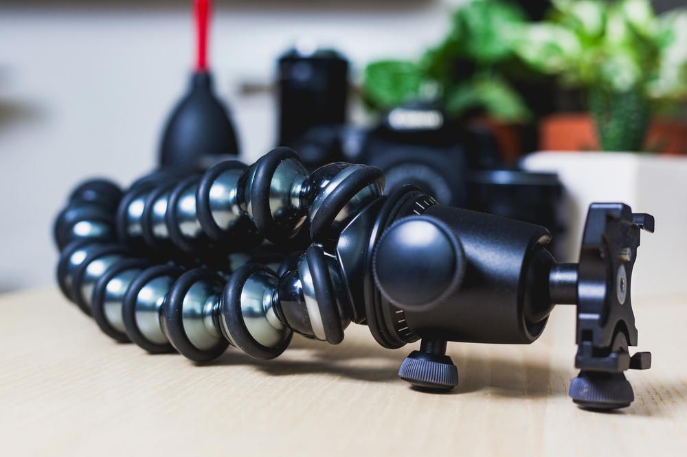 A close up of a joby bendable tripod on a table