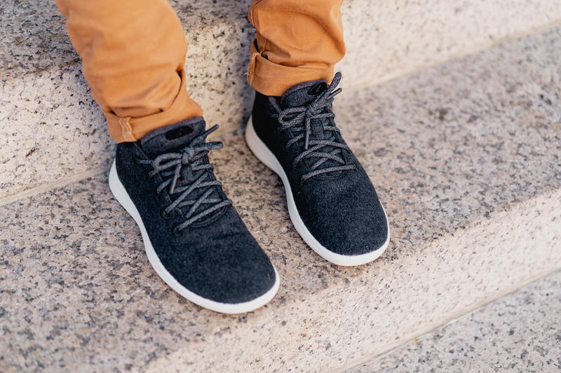 Close up of the Allbirds runner up mizzles in dark gray on stone steps