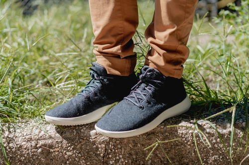 Close up of the Allbirds runner up mizzles in dark gray standing on a curb