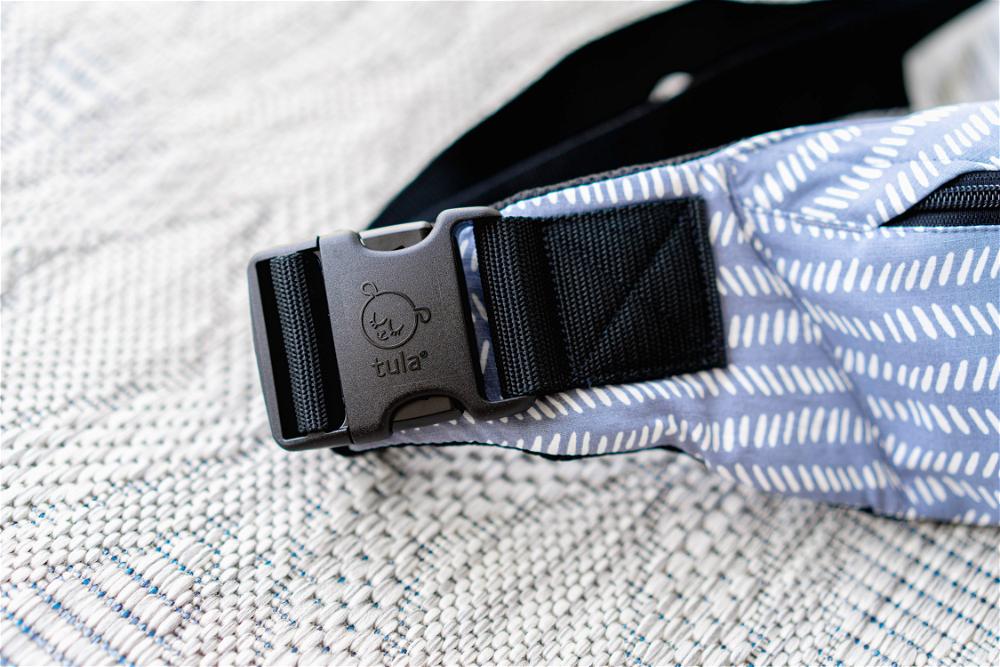 A close up of the buckle on the baby tula lite carrier.