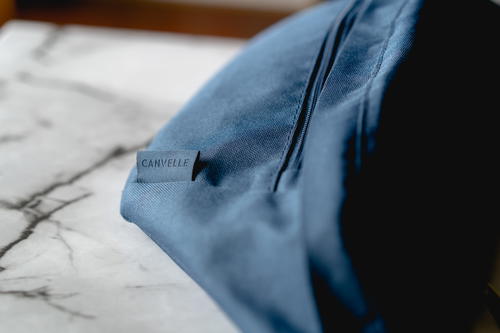 Close up of the logo tag on the Canvelle oversized fanny pack.