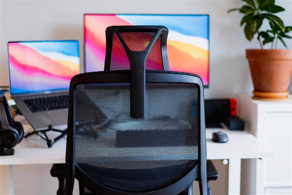 A desk chair with a monitor and a laptop.