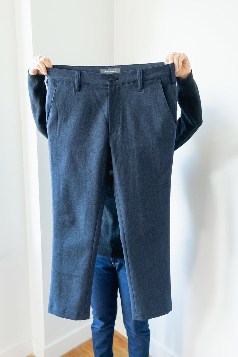 Woman folding Bluffworks suit pants