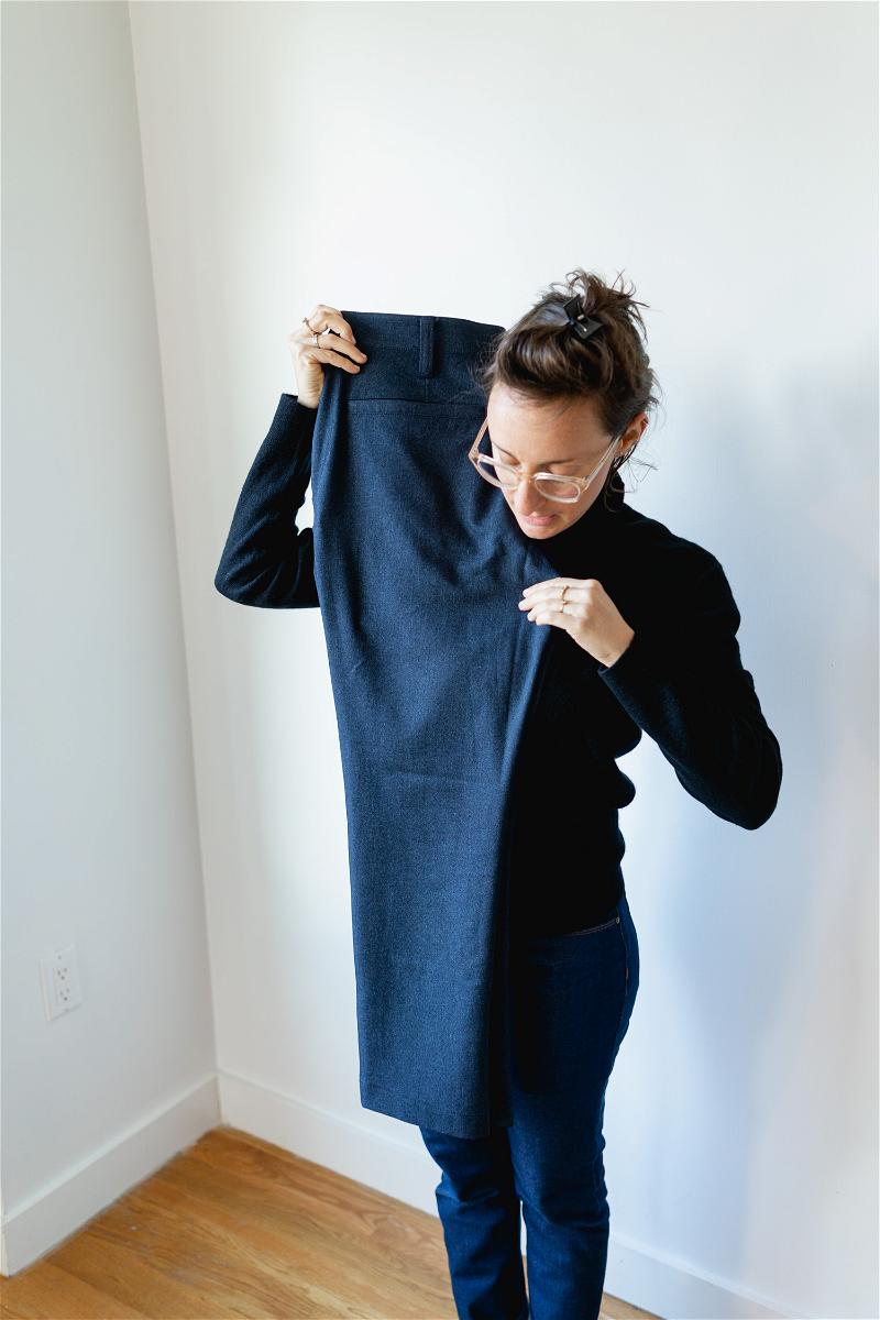 Woman folding Bluffworks suit pants