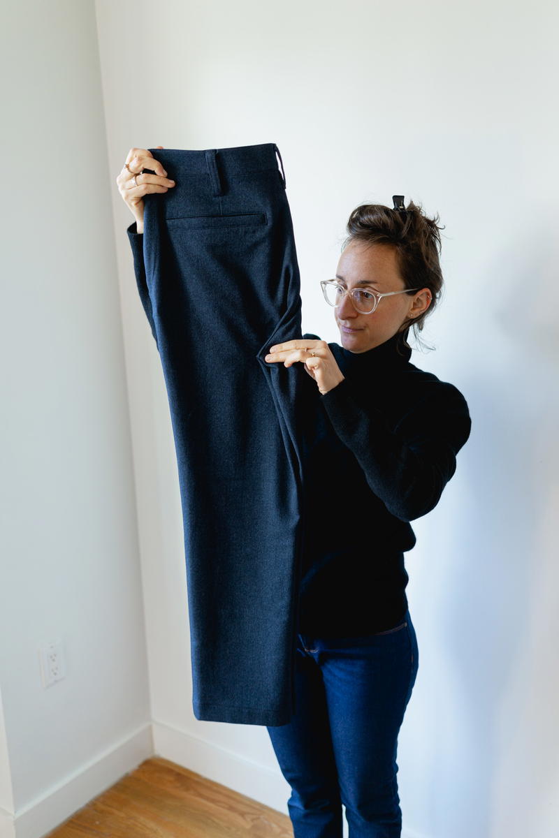 Woman folding Bluffworks suit pants