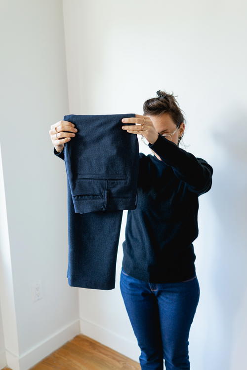 Woman folding Bluffworks suit pants