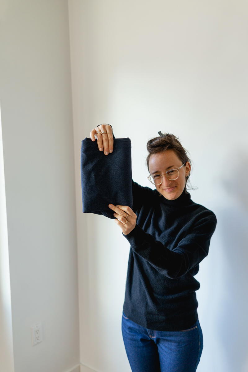 Woman folding Bluffworks suit pants