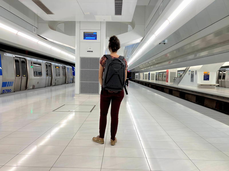 Woman wearing gray Small Expandable Knack Pack at the World Trade Center PATH Train platform