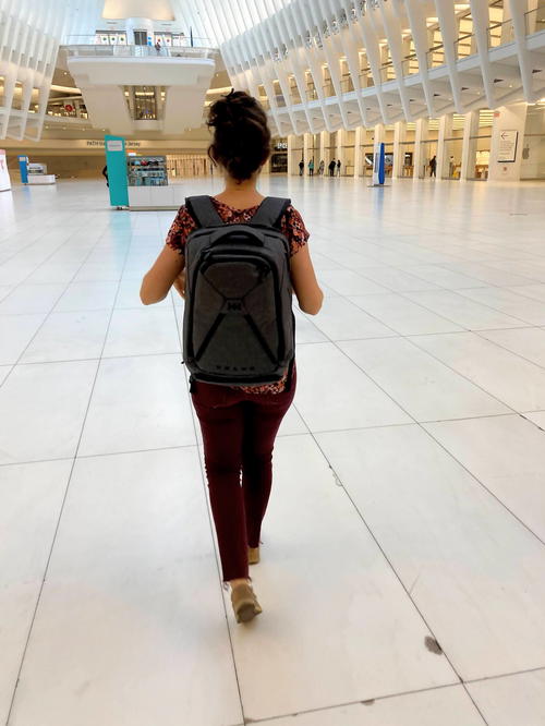 Woman walking through the Oculus at the world trade center wearing the gray Small Expandable Knack Pack