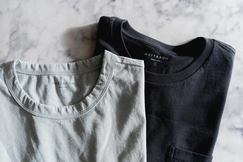 Two Mott & Bow t-shirts. A black shirt on top of a light green shirt