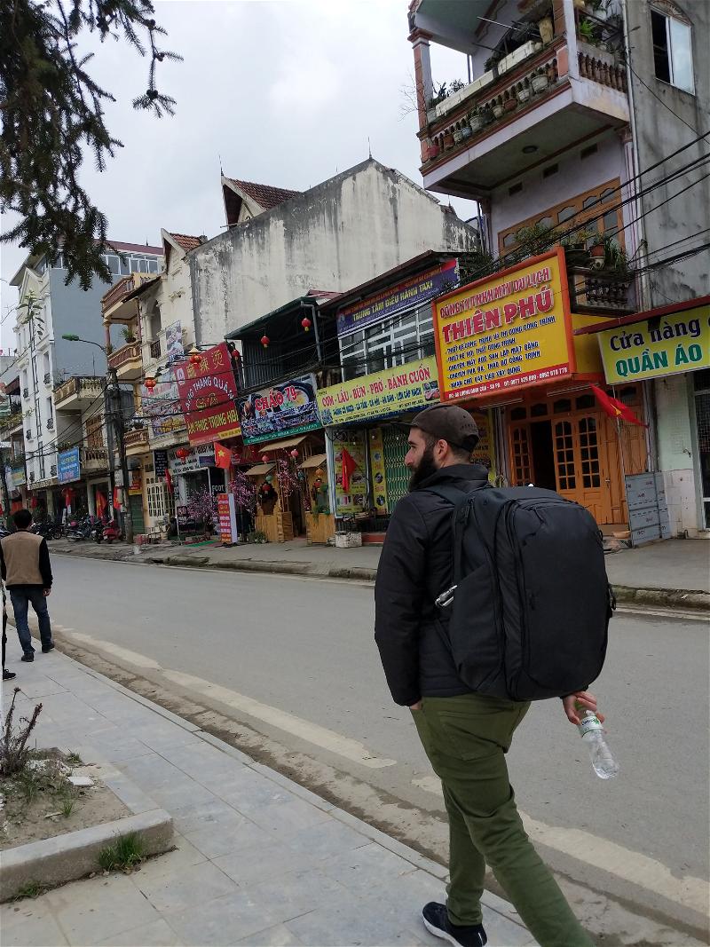 Man walking in an asian city with the peak design travel backpack 45L.
