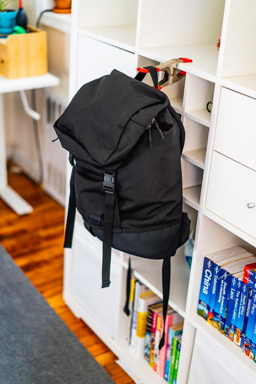 Top Bihn Shadow Guide 23L backpack hanging on a bookshelf