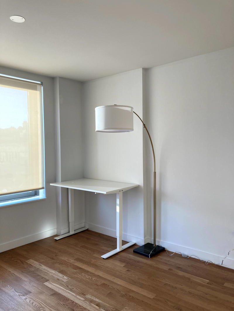 An empty room with a desk and a lamp.