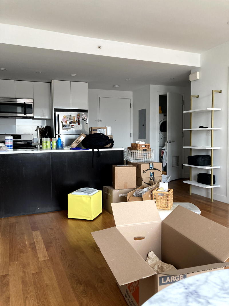 A living room with boxes on the floor.