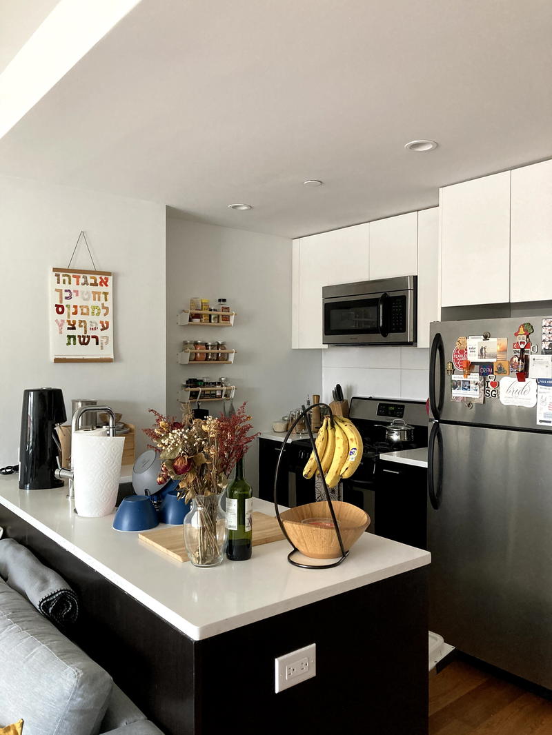 A living room with a couch and a refrigerator.