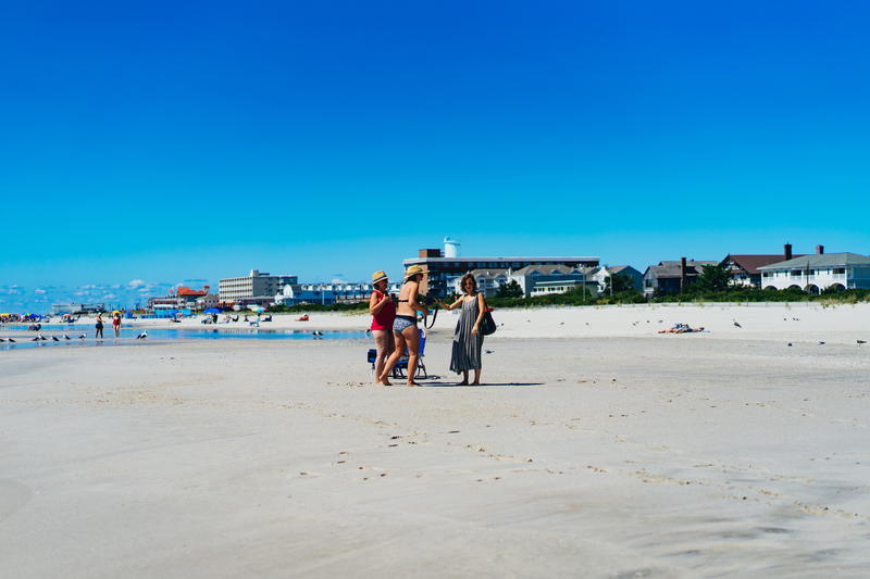 A group of people walking on a beach.