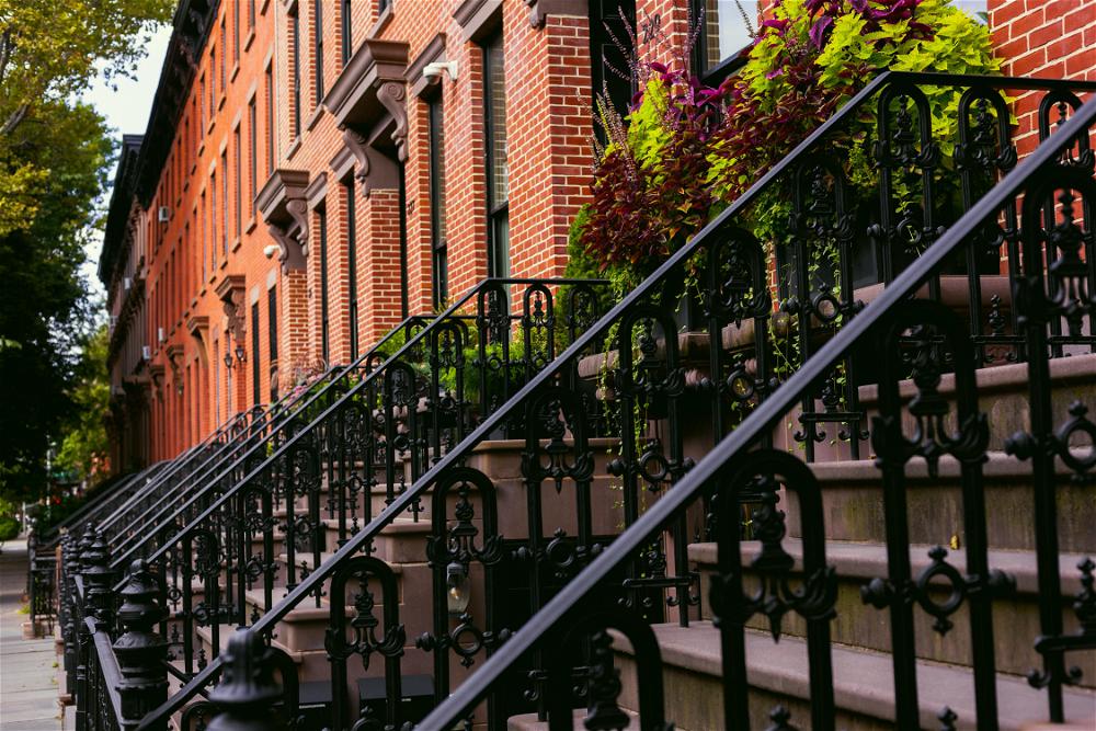 A row of brick buildings with wrought iron railings.