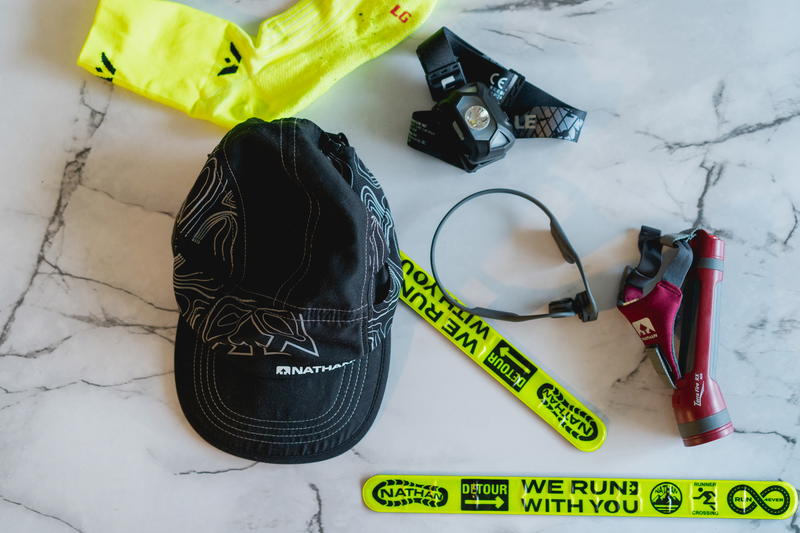 A hat, sunglasses, and other items are laid out on a marble table.