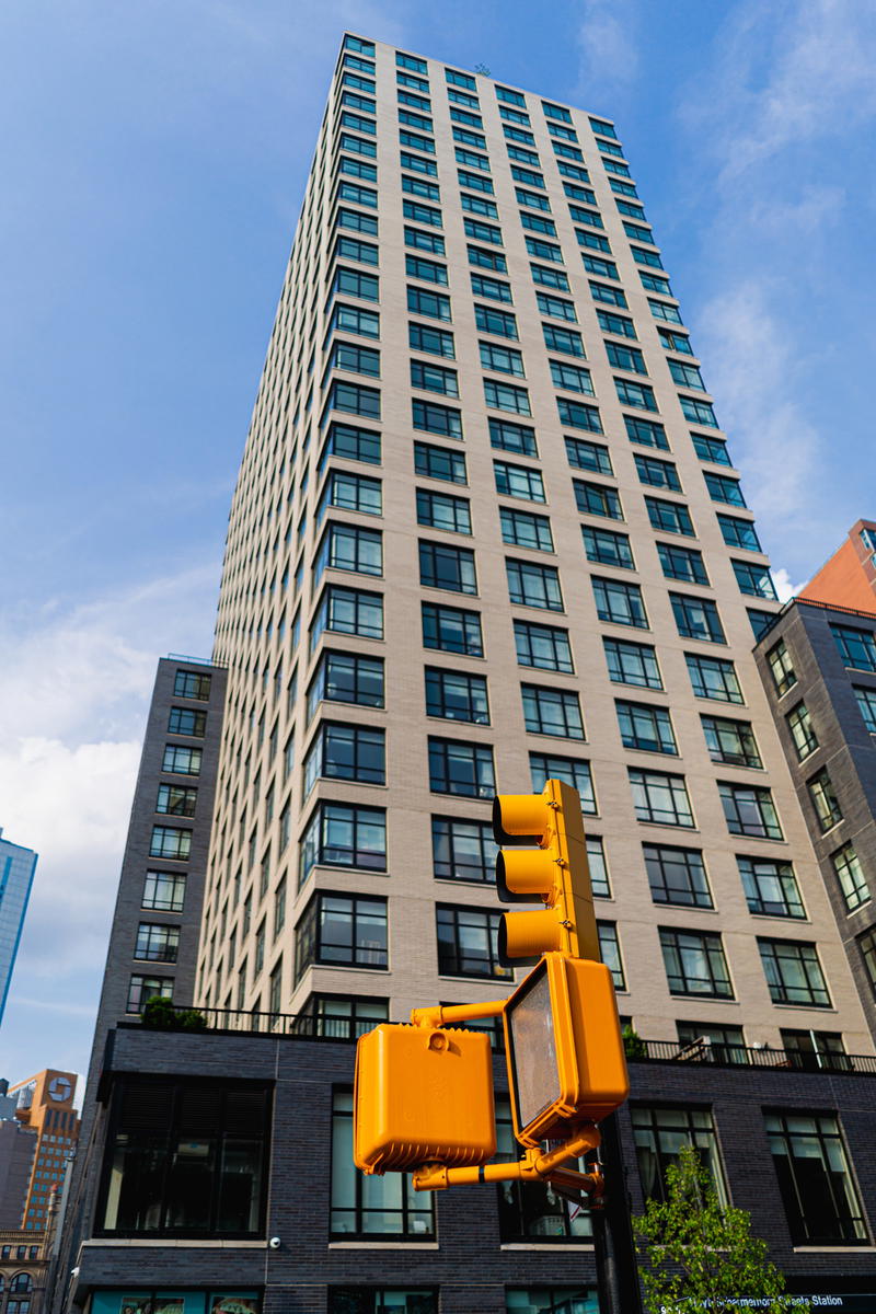 A traffic light in front of a tall building.