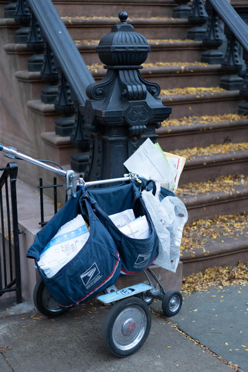 A blue cart on a sidewalk.