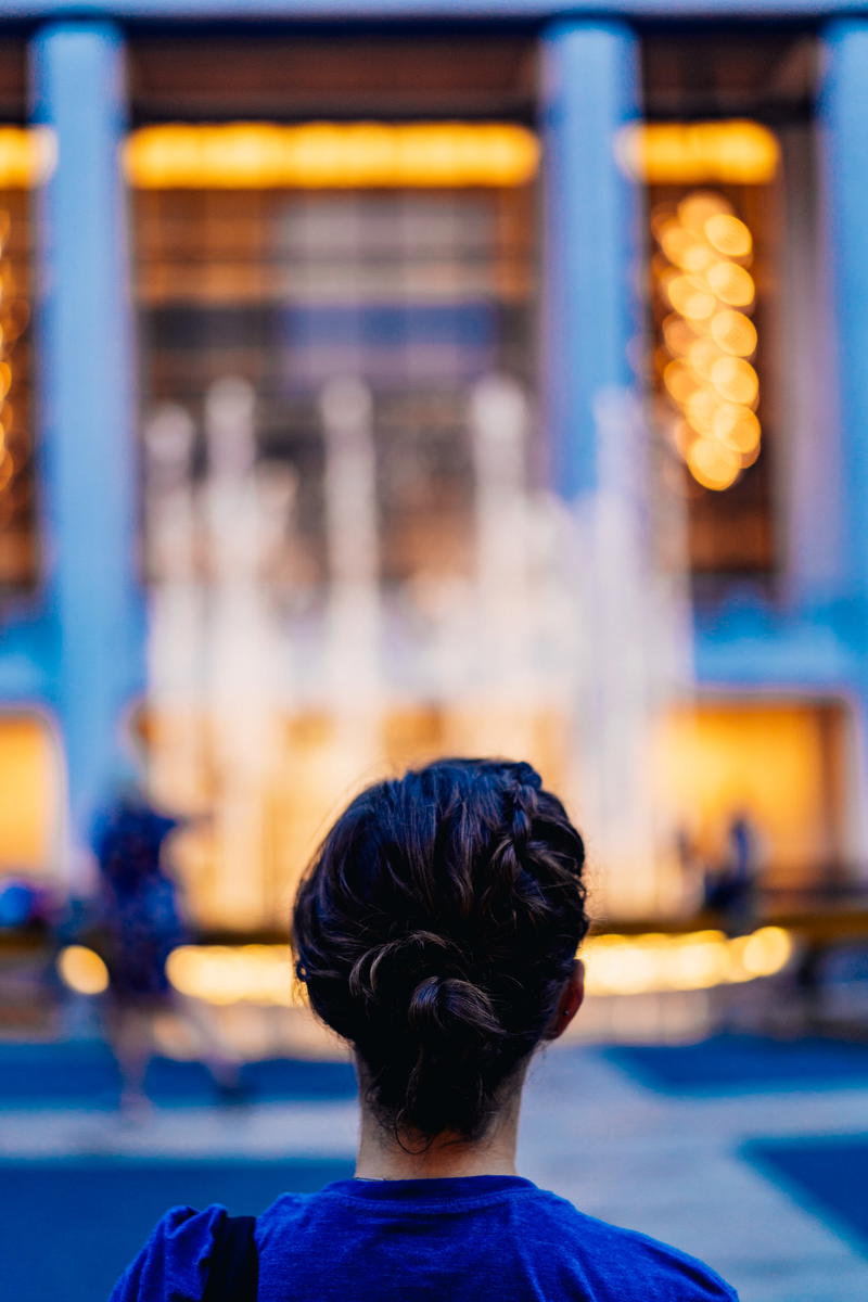 A woman standing in front of a building at night.