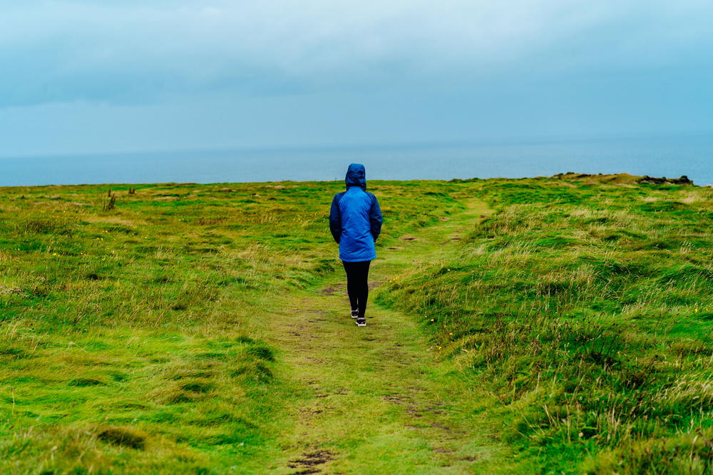 A person walking along the Wild Atlantic Way towards the ocean in Ireland.