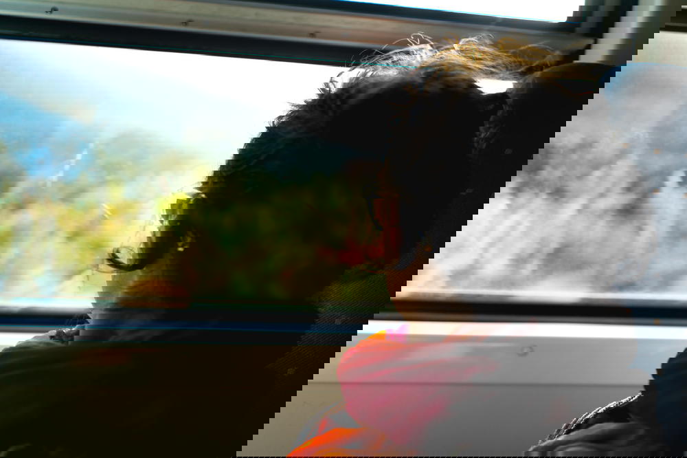 A woman peering out a train window in Sri Lanka.