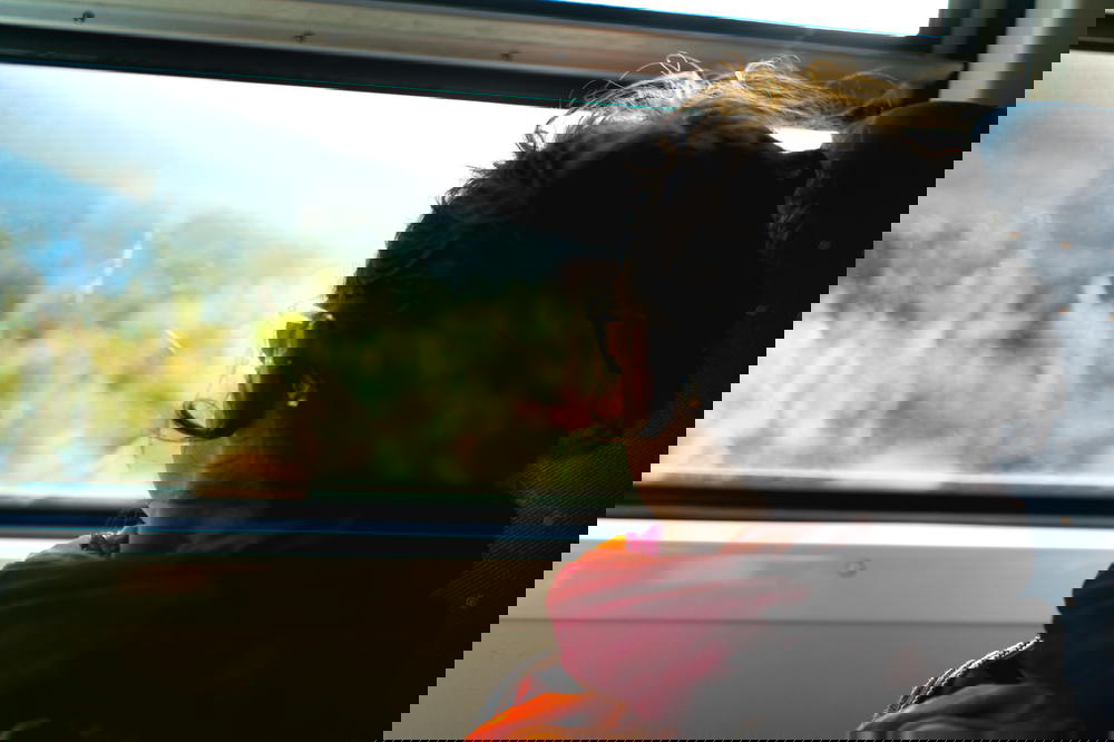 A woman peering out a train window in Sri Lanka.