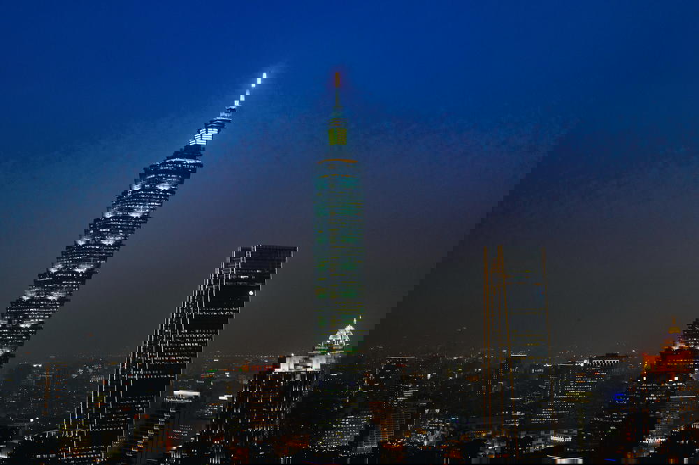 Taipei 101 lit up at night with a fading blue sky