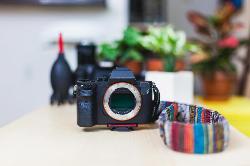 A camera sitting on a table with a colorful strap.