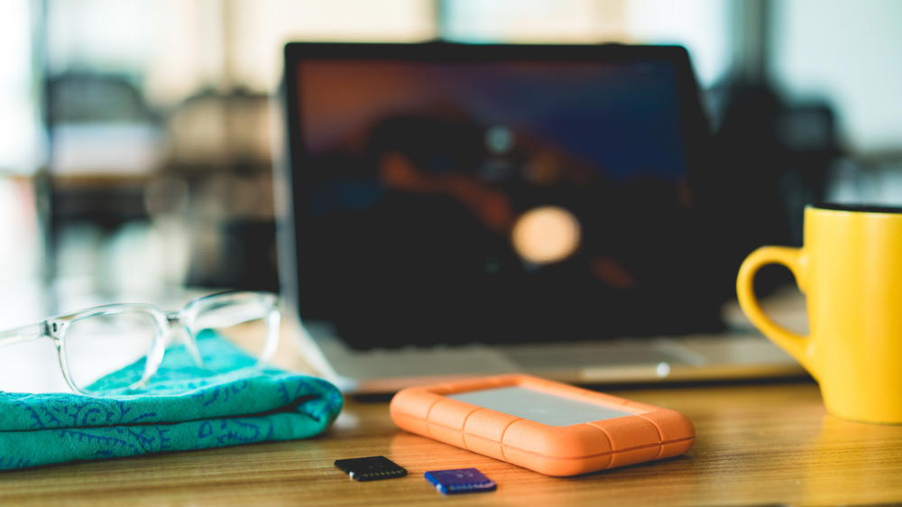 A laptop on a table next to a cup of coffee.