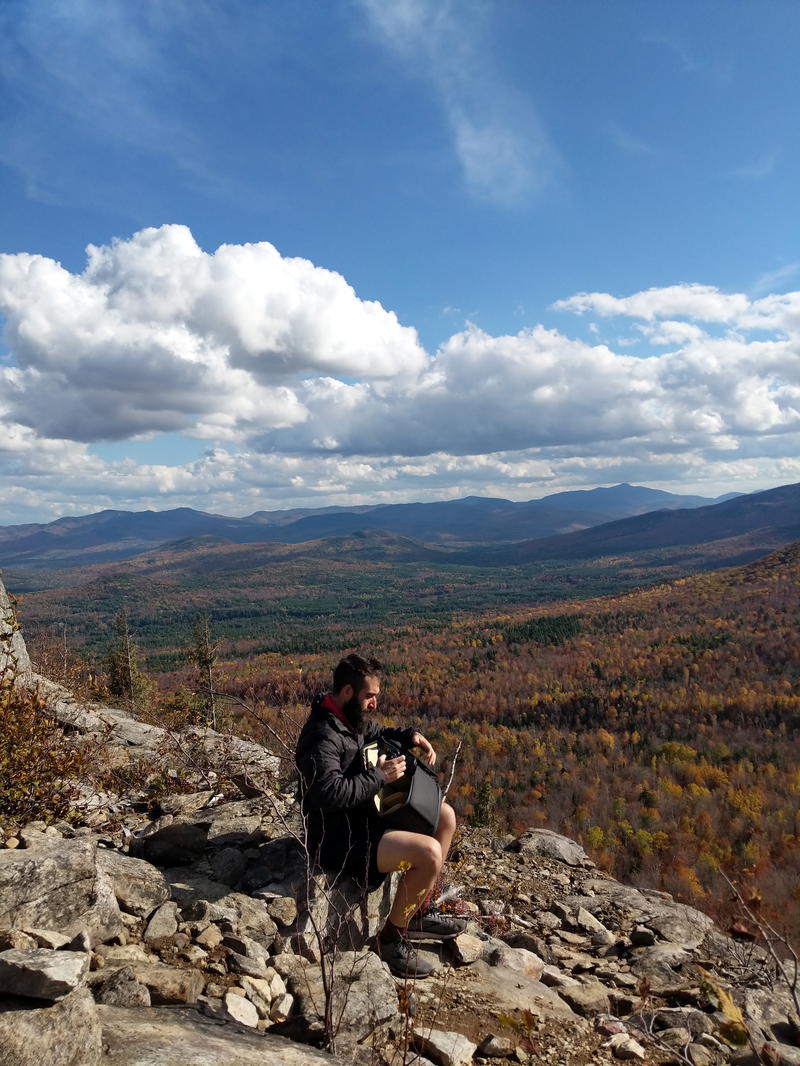 A man sitting on top of a rocky mountain.