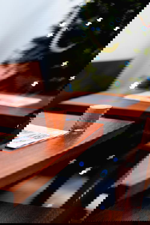 Latte in a small glass cup on a wooden table at a trendy coffee shop in Mexico City