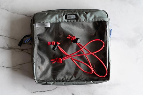 A pair of earphones in a bag with a red cord.