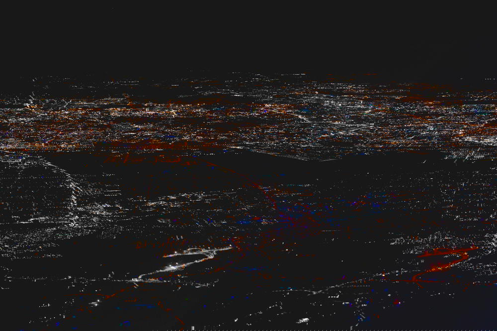Photo of City lights taking photos from airplane window aerial view