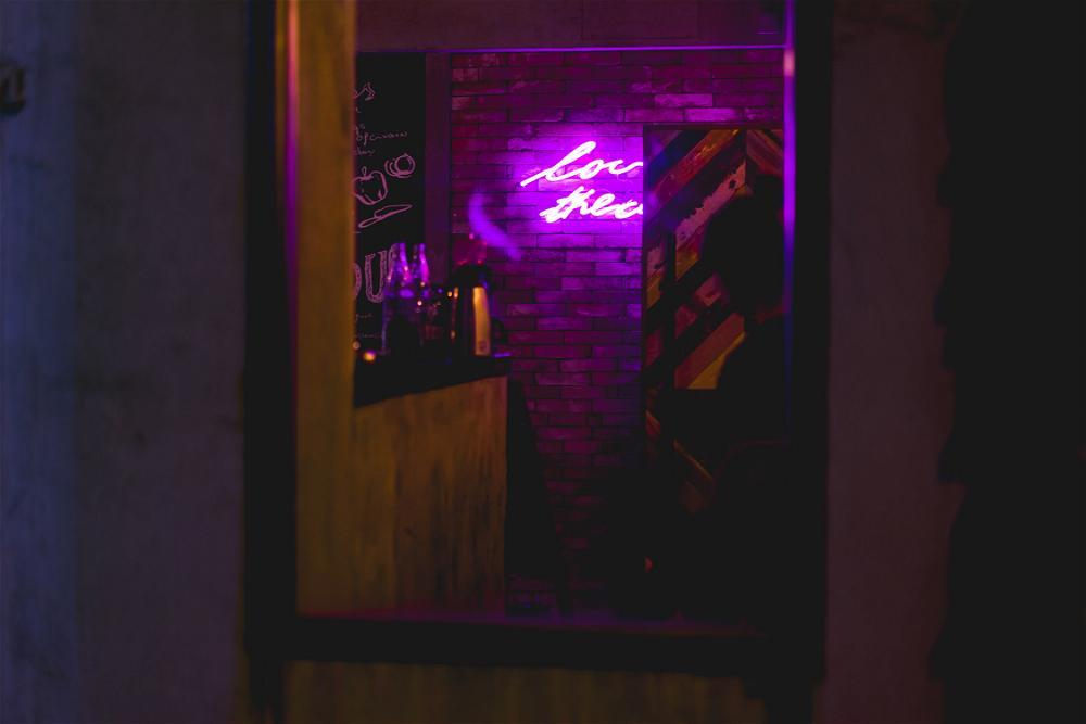 Purple Neon sign through a window how to take photos of neon signs