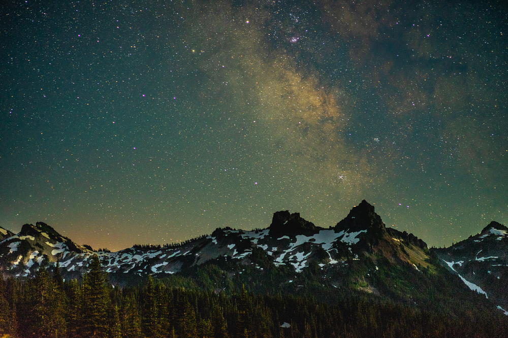 The milky lights up the sky over a mountain range.