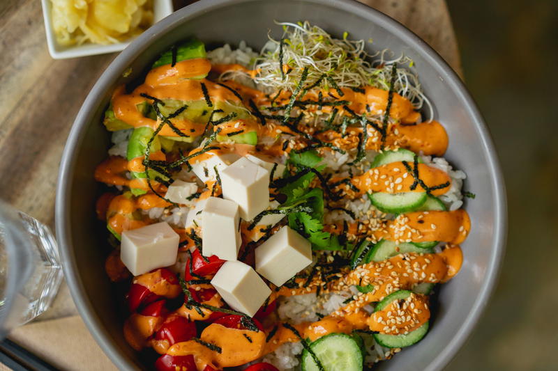 A bowl of rice, vegetables and tofu.