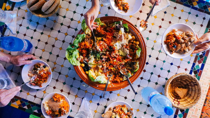 A group of people eating food at a table in morocco.