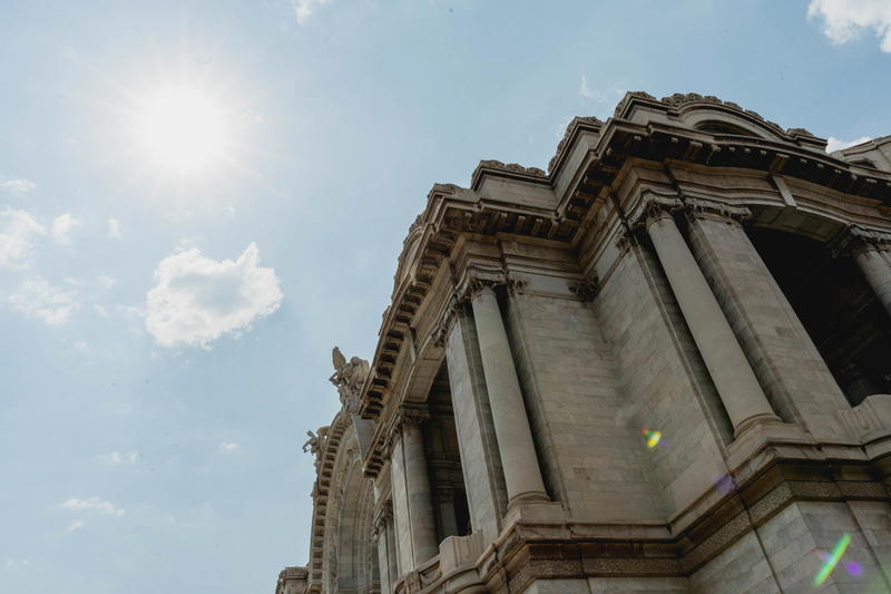 An ornate building with a sun shining on it.