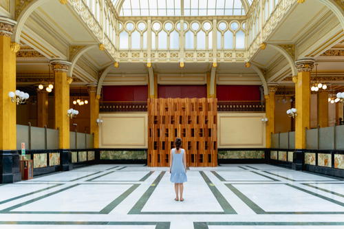 A woman is standing in an ornate building.