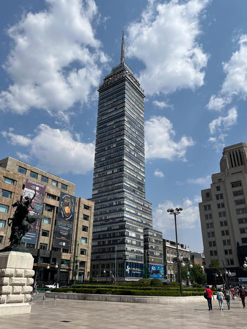 A tall building in the middle of a plaza.