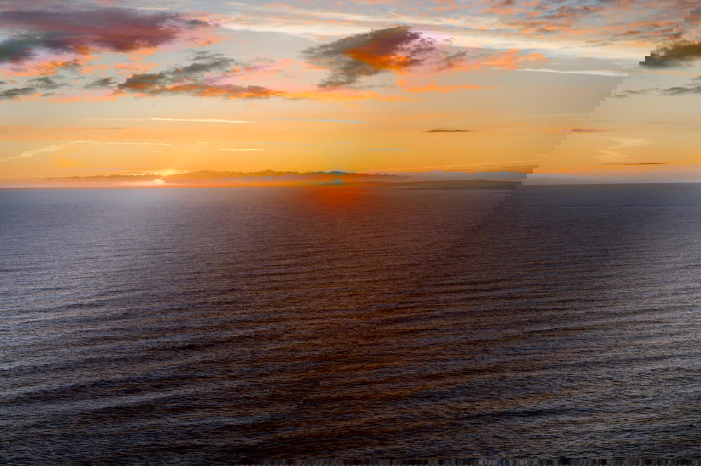 Golden sunset on the water with purple clouds