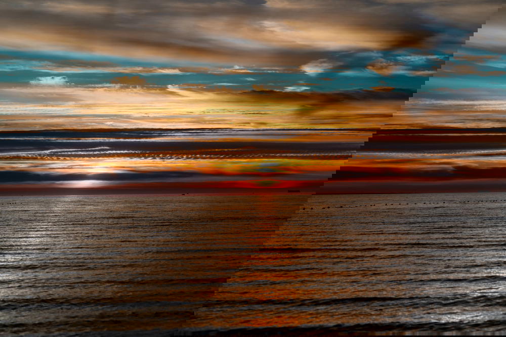 Dark and colorful sunset with long cloud bands