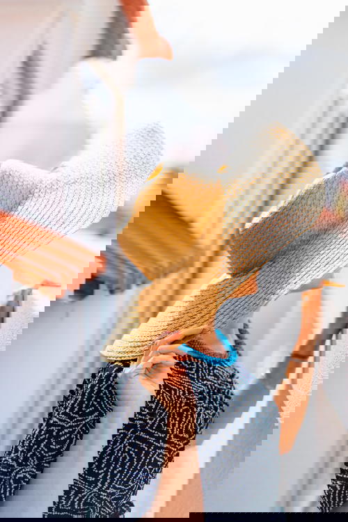 A woman wearing a hat on a balcony.