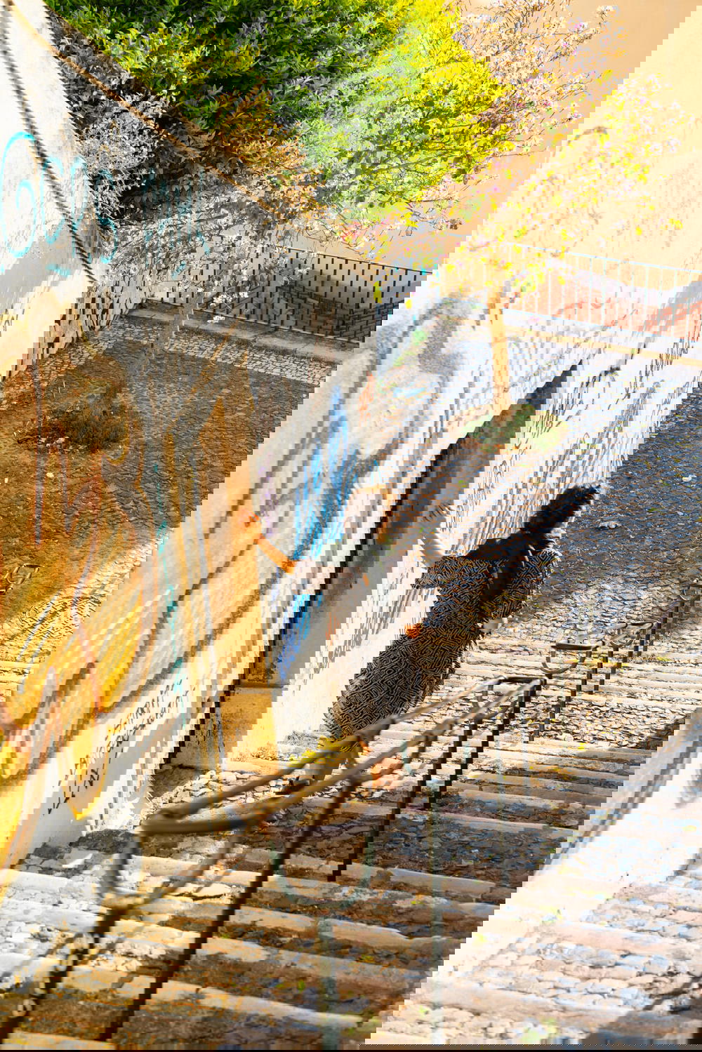 A woman riding a skateboard down a set of stairs.